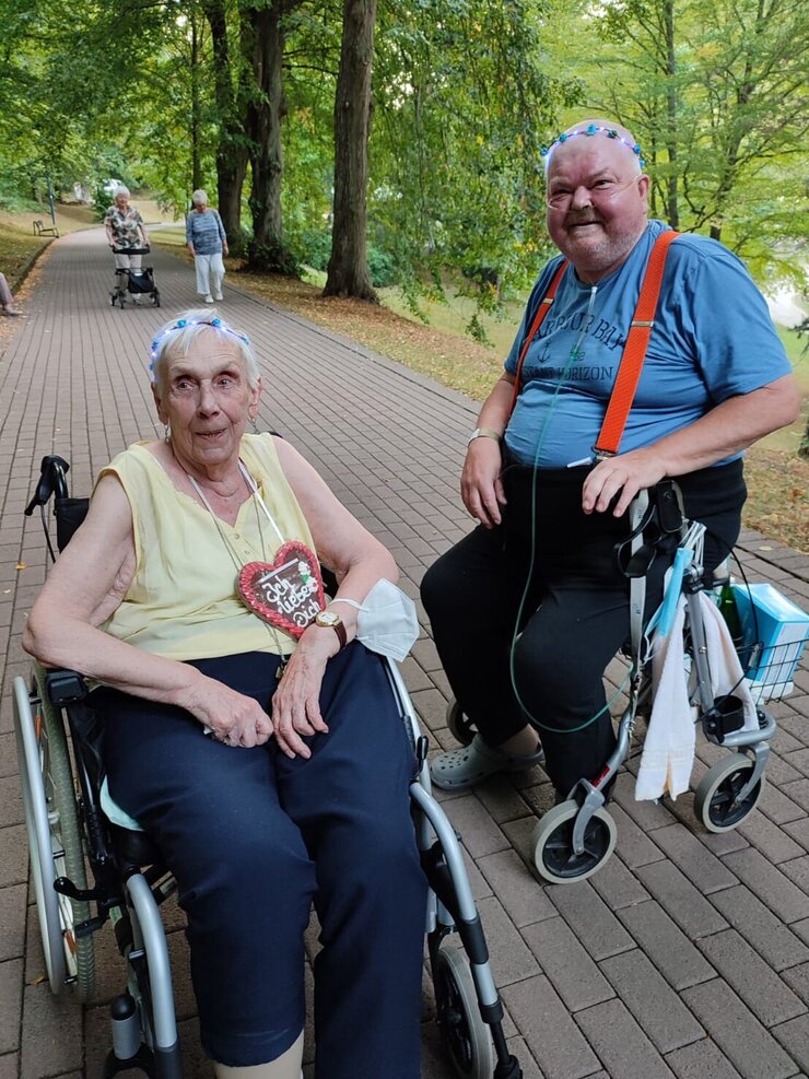 Bewohner mit Rollstuhl und Rollator beim Spaziergang