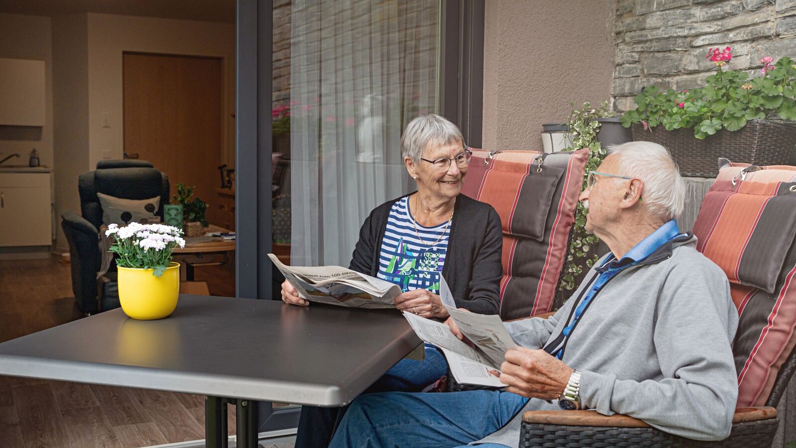 Bewohner-Ehepaar beim Zeitunglesen auf der Terrasse