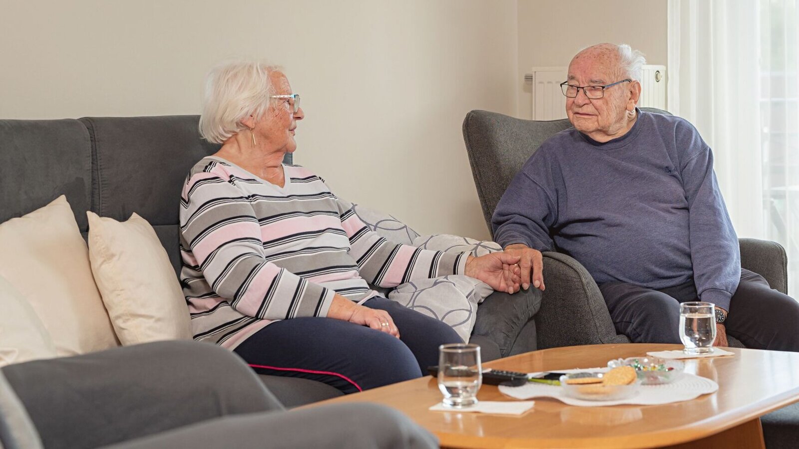 Bewohner-Ehepaar sitzt zusammen im Wohnzimmer