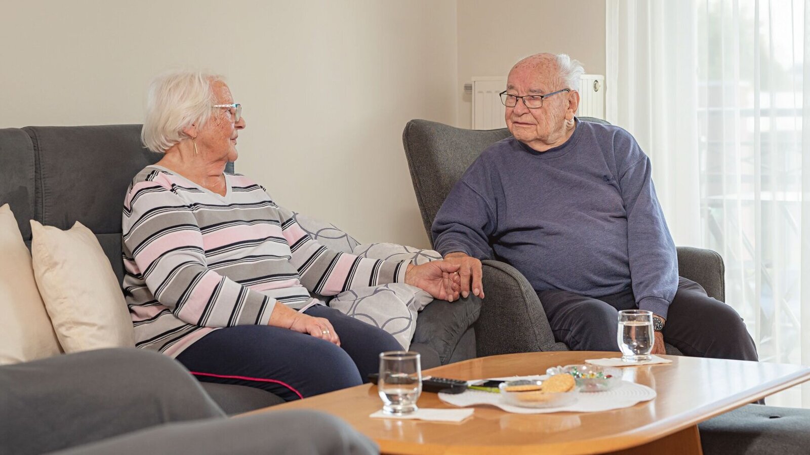 Bewohner-Ehepaar sitzt zusammen im Wohnzimmer